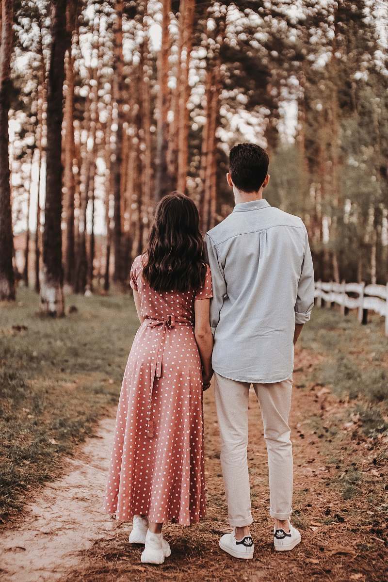 Capture the essence of love and togetherness with this beautiful image of a man and woman standing side by side, dressed in stylish apparel. This scene, set amidst a serene forest path, embodies tranquility and romance, making it perfect for themes around relationships, nature, and fashion. Ideal for use in articles on love, outdoor activities, or lifestyle blogs, this image conveys a sense of adventure and connection.